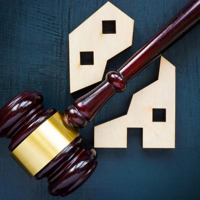 A wood house block separated by a gavel into two parts.