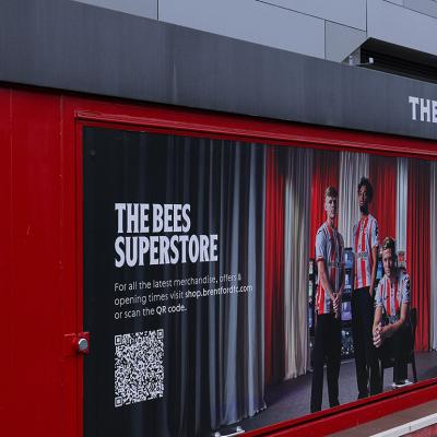 A Brentford Football Club merchandise kiosk promoting The Bees superstore with a QR code in London, United Kingdom.