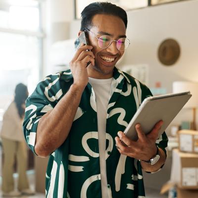 A man on the phone and looking at a tablet for an order.