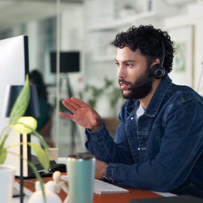 A male customer service representative on call with a client.