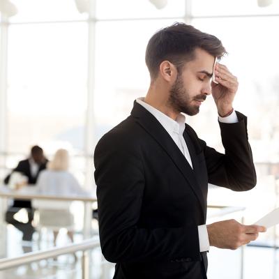 A business employee sweating and feeling nervous before speaking to an audience.