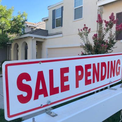 A sale pending sign in front of a house.