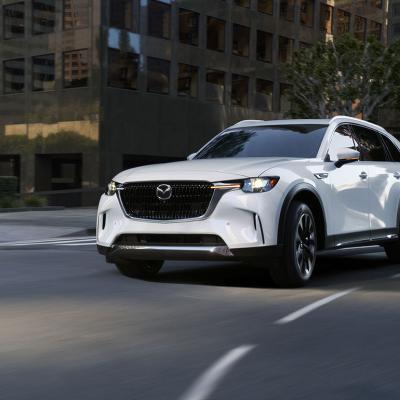 A white Mazda CX-90 on the road.
