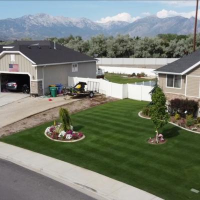 Aerial view of Jimmy Lewis’s golf course-like lawn in Utah, with striping patterns in green grass and three small trees in yard.
