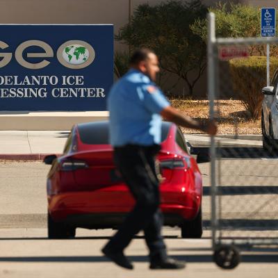 An officer closing a security gate at the GEO Group Adelanto ICE Processing Center in California.