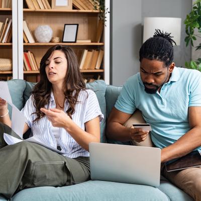 A couple at home stressfully reviewing household bills.