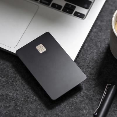 A black credit card on the edge of a laptop.