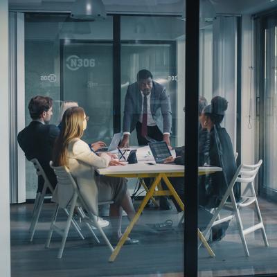 A focused team manager leading a meeting in a conference room.