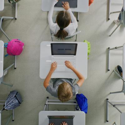 Ceiling view of students working on projects on their laptops inside the classroom.