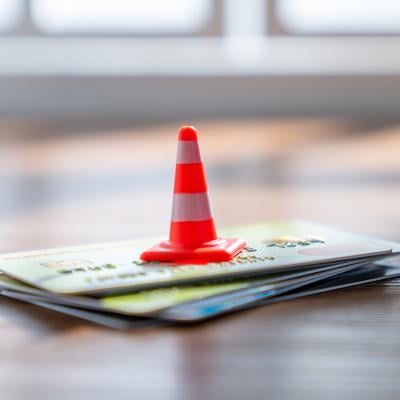 A traffic cone on a stack of credit cards. 