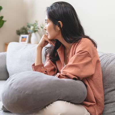 Stressed young woman at home sitting on a sofa.
