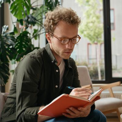 A person taking notes while working in an office.
