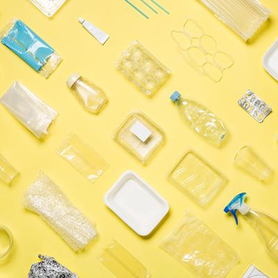 Different types of plastic packaging neatly arranged with a yellow background.