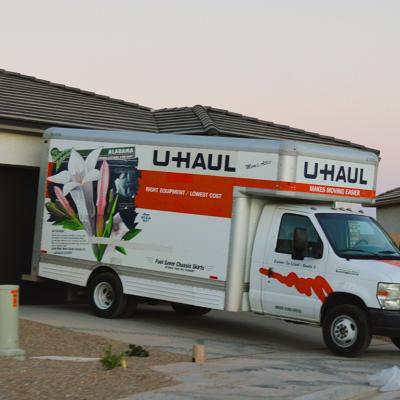 A U-Haul moving van parked in front of a newly built home.