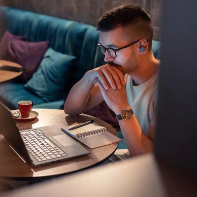 A focused male professional working from a cafe.