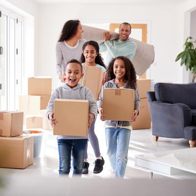 A family of five happily moving boxes into new home.