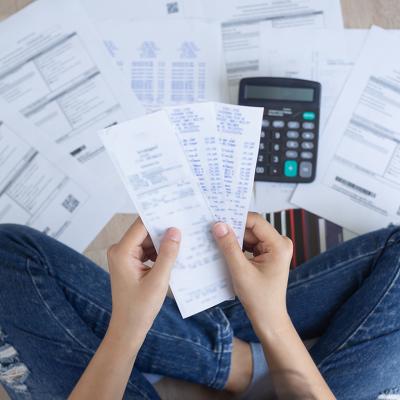 Person arranges bills and expenses on the floor.