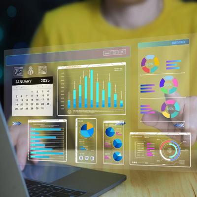 Set of business intelligence dashboard graphics over a person working on a laptop.
