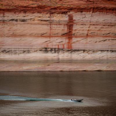 A powerboat cuts through the water on Lake Powell near Glen Canyon Dam in Page, Arizona.