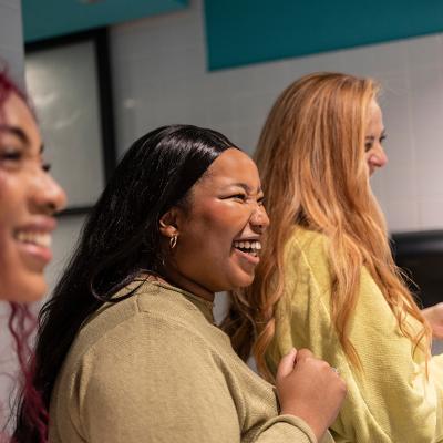 Three young women enjoying a lighthearted moment together in a restroom.