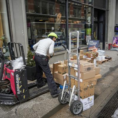 Delivery staff arrange provisions to a bakery in New York City.
