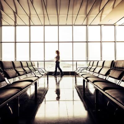 Woman waiting by the departure gate area in an airport.