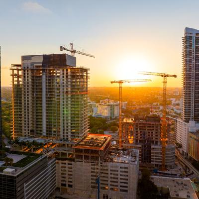 Aerial view of tower cranes at an industrial construction site in Miami, Florida.