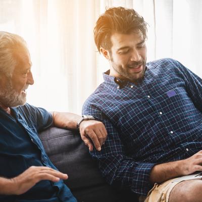 A senior father with his adult son discussing matters at home.