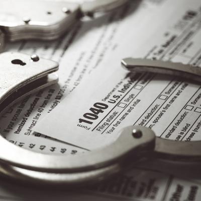 Handcuffs over U.S. tax 1040 forms.
