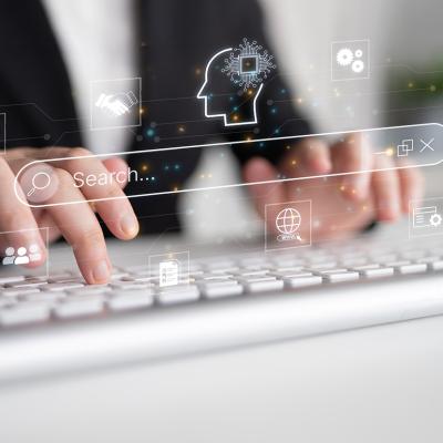 Generative search engine graphics illustrated over a person typing on a keyboard.