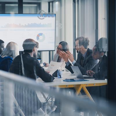 A business team inside a conference room discussing reports.