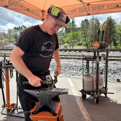Scotty Utz, RAWtools South’s blacksmith, leads a demonstration at the 2025 Fire on the Mountain Festival in Spruce Pine, North Carolina.