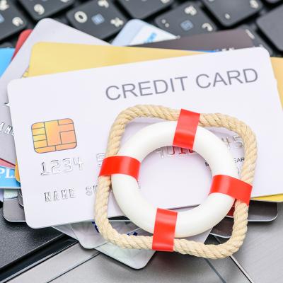 A small red lifebuoy on top of credit cards.