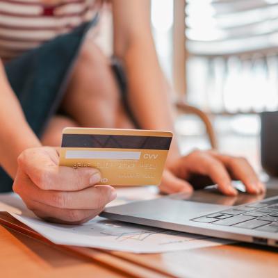 Person holding a credit card to purchase online.