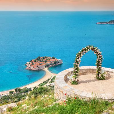 A romantic wedding ceremony at Montenegro Sveti Stefan viewpoint, with an arch adorned in flowers overlooking the Adriatic Sea.