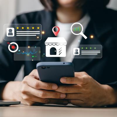 Businesswoman using a phone and illustrated with local SEO insight graphics. 