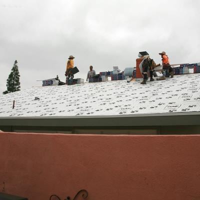 A construction team replacing a home's roof.