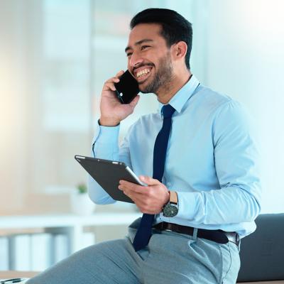A happy businessman talking on the phone with a client.