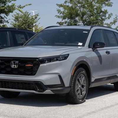 A gray Honda CR-V Hybrid AWD TrailSport compact SUV displayed at a dealership.