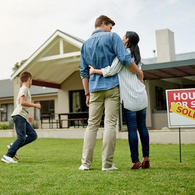 A family of four celebrating on the yard of their new home.