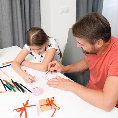 A father and daughter do arts and crafts for Mother's Day.