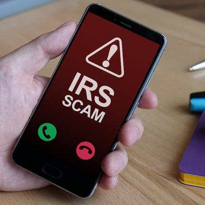An Internal Revenue Service (IRS) scam call is displayed from a smartphone.