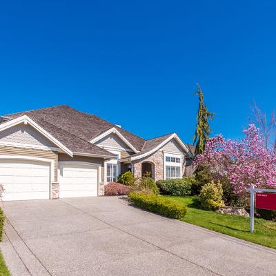 A multi-car garage residential property with a for sale sign.