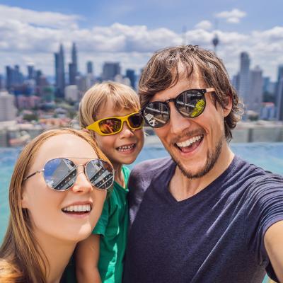 A family taking a selfie together with a view of a pool and city sky line.
