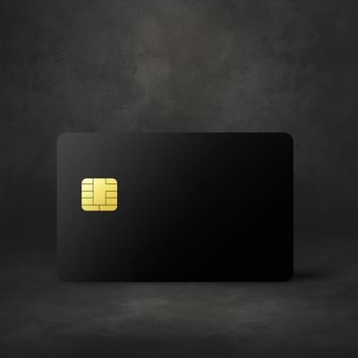 A black credit card in a dark concrete background.