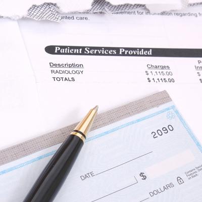 Medical bill statements and a check with a pen.