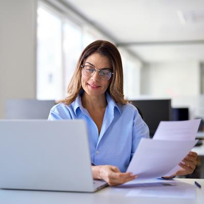 A businesswoman reading tax papers in an office.