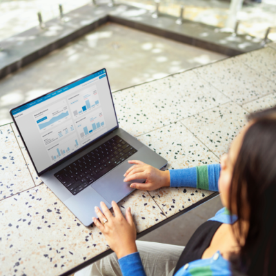 A person checking financial graphs and charts from a laptop.