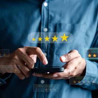 Man using a phone illustrated with graphics depicting rating customer service online.