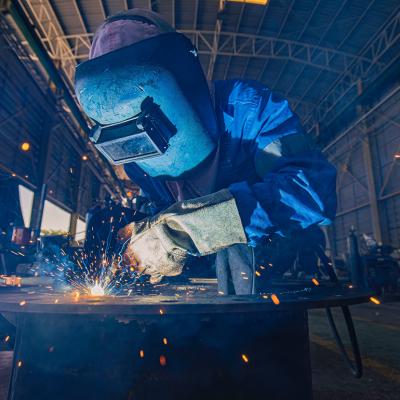 A person doing a mig welding on steels in a warehouse.